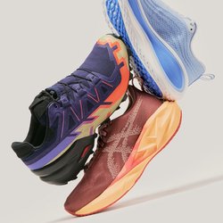 Tři barevné sportovní boty umístěné ve vzduchu na jednoduchém světle šedém pozadí, s modrými, fialovými a červeno-oranžovými vzory.