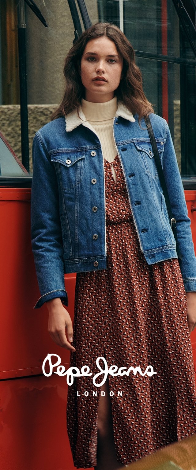 Jeansjacke mit Schaffellkragen, getragen über einem braun gemusterten Kleid. Das Ensemble verfügt über eine taillierte Passform und einen A-Linien-Rock.