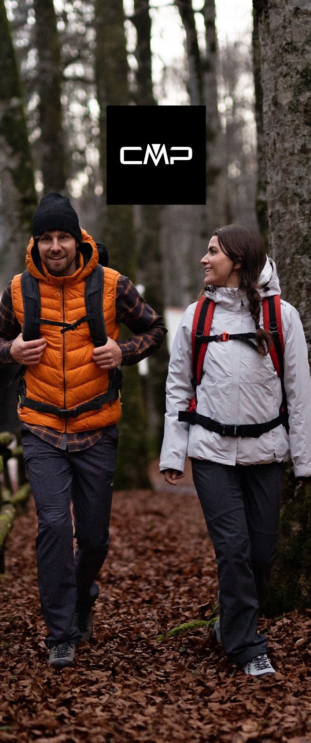 Twee wandelaars op een bospad. De ene draagt een oranje geïsoleerd vest, een zwarte muts en een gemêleerd shirt; de andere heeft een witte jas met rode accenten.