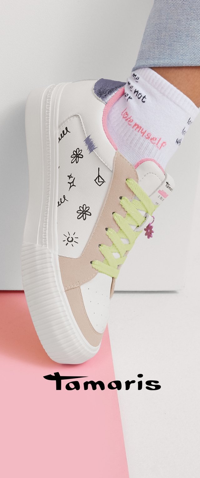 Zapatilla blanca y beige con cordones verde claro, garabatos negros, usada con calcetines blancos que dicen "me quiero", sobre un suelo dividido en rosa y blanco.