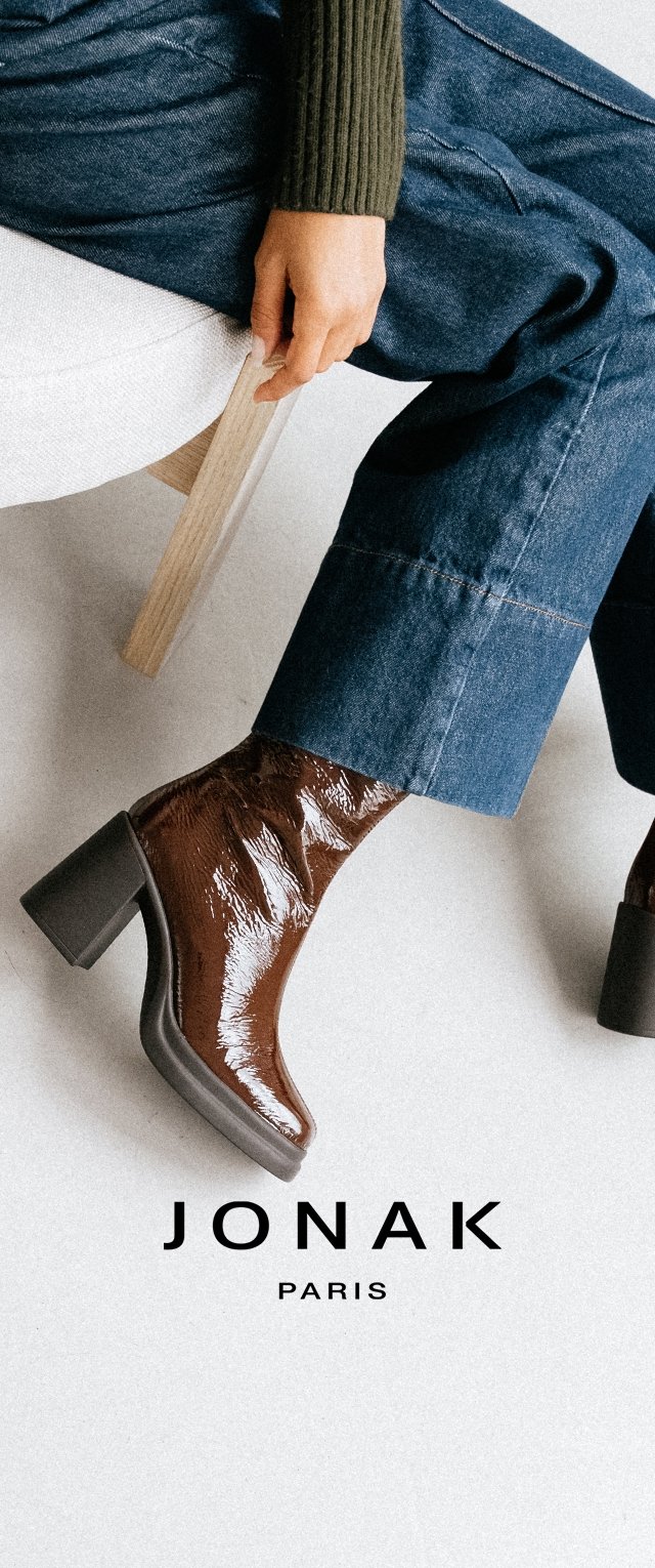 Bottes de cheville en cuir verni marron avec un talon carré. Fini brillant, bout pointu et surface texturée. Portées avec un jean large bleu.