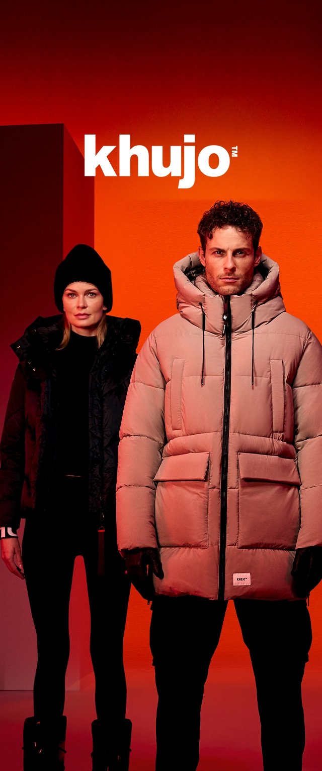 Man in beige gewatteerd jack en vrouw in zwarte winterjas met muts staan tegen een oranje achtergrond met het "khujo" logo erboven.