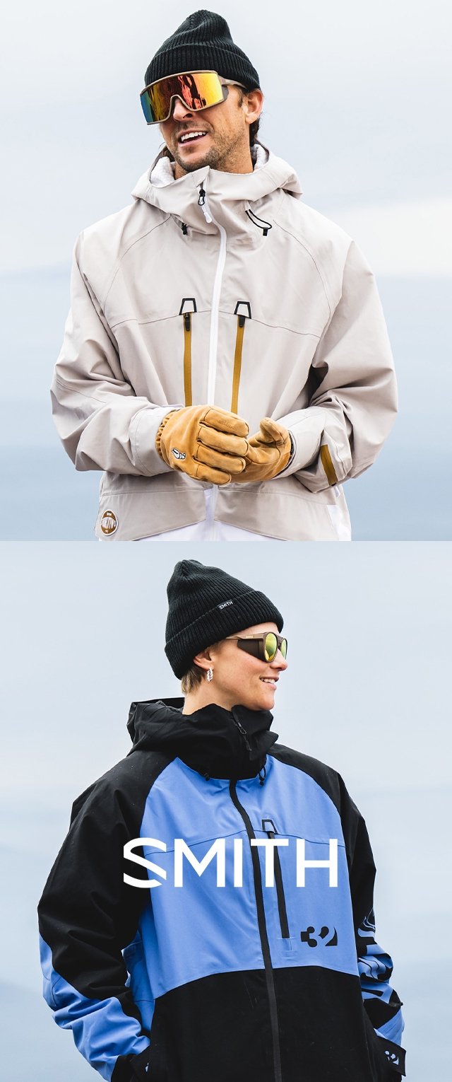 Dwóch mężczyzn w kurtkach sportowych zimowych. Jedna kurtka jest jasnoszara z zamkami błyskawicznymi, druga czarna i niebieska z detalami logo. Obaj noszą czapki.