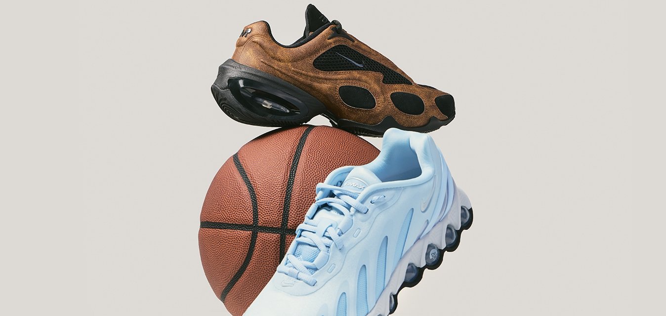 Hnědé a světle modré sportovní boty vyvážené na basketbalovém míči na jednoduchém světle šedém pozadí.