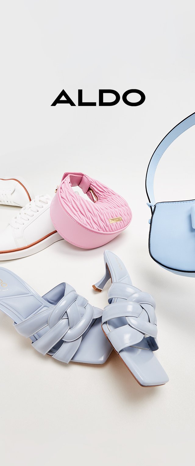 Sandalias de tacón alto azul claro con tiras trenzadas, un bolso acolchado rosa en forma de círculo, una zapatilla blanca con acentos marrones y un bolso azul claro.