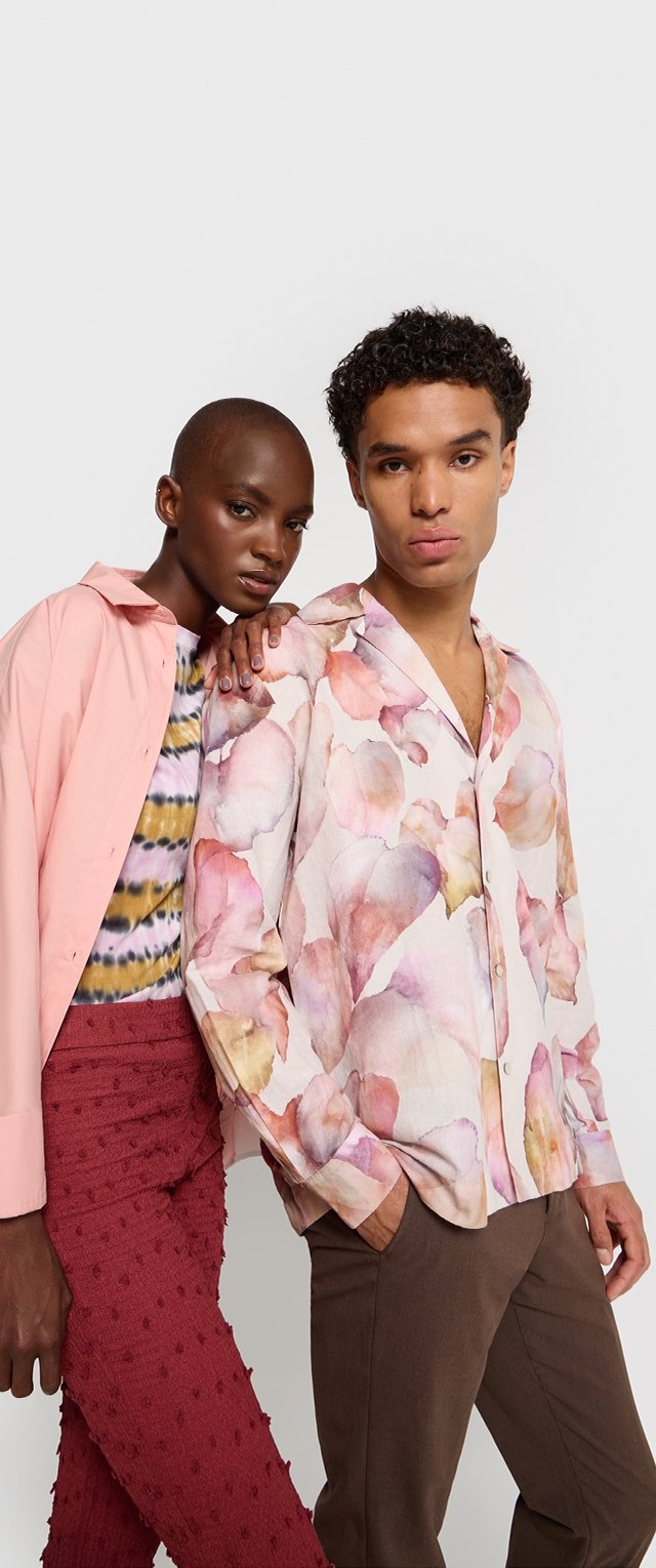 Bluzka w kwiaty w delikatnych pastelowych kolorach, zapinana na guziki z przodu; różowa otwarta kurtka; paskowany top; teksturowane burgundowe spodnie; dopasowane brązowe spodnie.