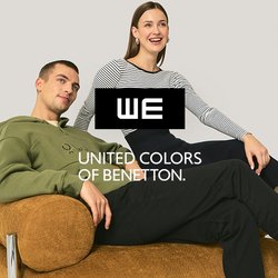 Zelená mikina s kapucí, pruhovaný top, černá sukně a béžové boty. Modelka sedí na hnědé texturované pohovce s chromovanými prvky na neutrálním pozadí.