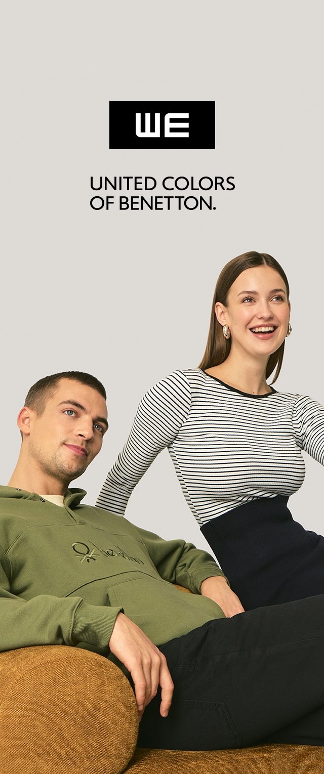 Groene hoodie met voorzak en geborduurd detail; model in marineblauwe strepen en zwarte broek, zittend op een bruine bank. Merkenlogo bovenaan.