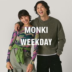 Mladý muž a žena stojí blízko sebe, usmívají se; žena má na sobě vzorovaný top a zelené kalhoty, drží černou kabelku, muž má na sobě strukturovaný svetr a černé kalhoty.