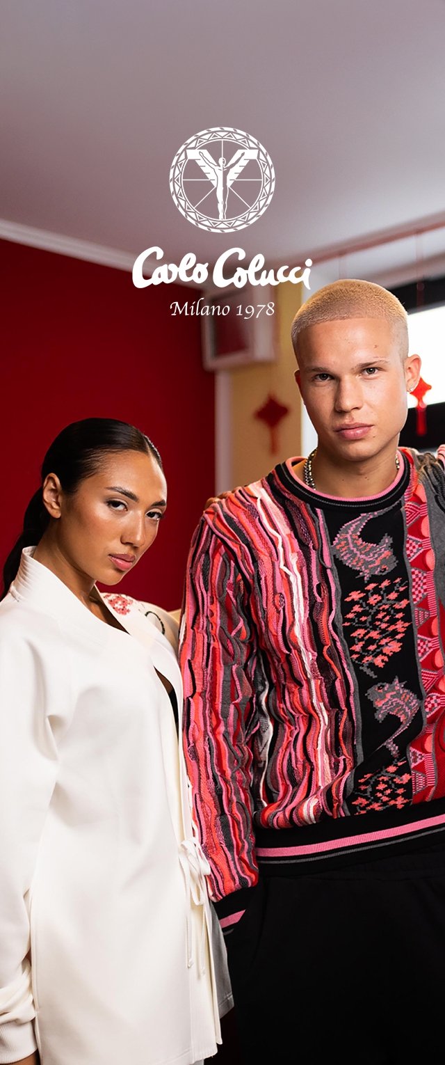 Zwei Models posieren drinnen; eines trägt ein weißes Sakko, das andere einen farbenfrohen, gemusterten Pullover. Das Logo "Carlo Colucci Milano 1978" erscheint darüber.