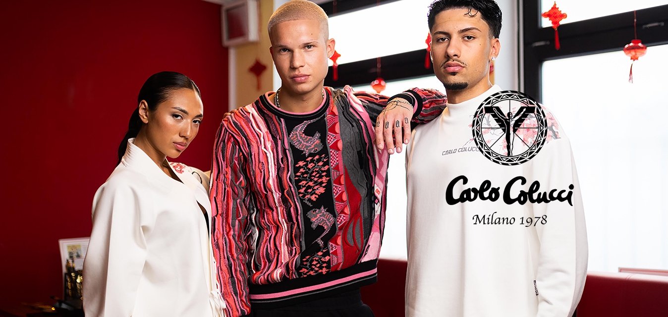 Tři lidé pózují uvnitř v moderním stylovém oblečení v červených a bílých odstínech na pozadí červené stěny a okna.