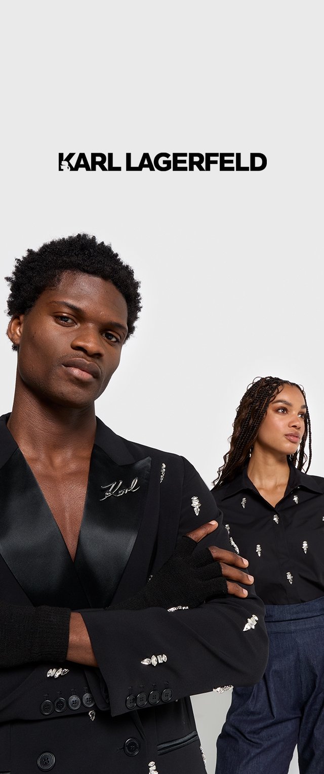 Zwarte blazer met satijnen revers en kristalaccenten, gedragen met zwarte handschoenen; model toont een shirt met vergelijkbare versieringen.