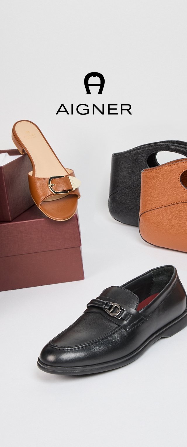 Zwarte leren instapschoenen met een zilveren gespdetail, tan schuifsandalen met een gouden accent, en een bruin en zwart peeptoe-bootie op bordeauxrode dozen.